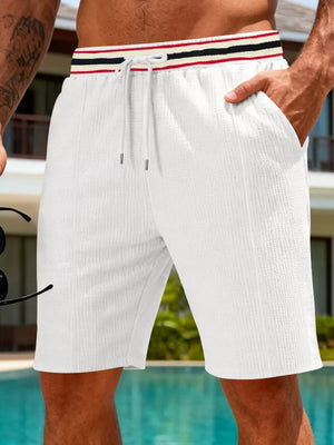 Textured drawstring shorts in white with a striped waistband and drawstring detail.