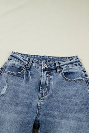Cuffed mid-rise relaxed fit jeans in distressed blue denim with pocket details.