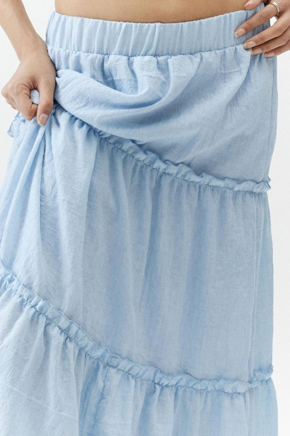 Tiered cotton maxi skirt in light blue with ruffled tiers and an elastic waistband.
