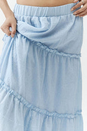 Tiered cotton maxi skirt in light blue with ruffled tiers and an elastic waistband.