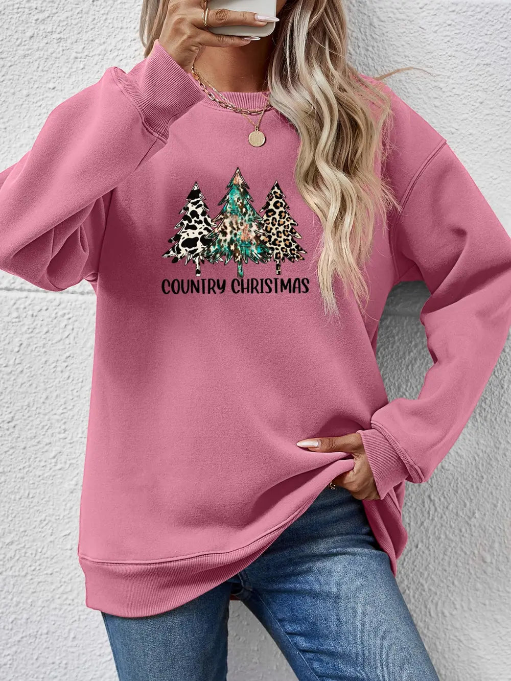 Blush pink graphic sweatshirt with country Christmas trees and text.