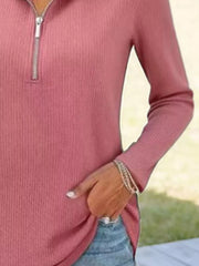Pink ribbed knit half-zip sweater with long sleeves.