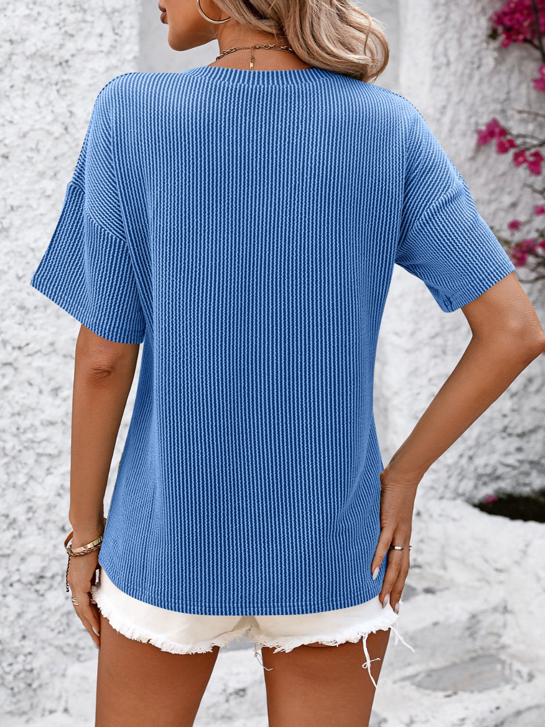 Blue ribbed V-neck t-shirt with short sleeves and a pocket detail.