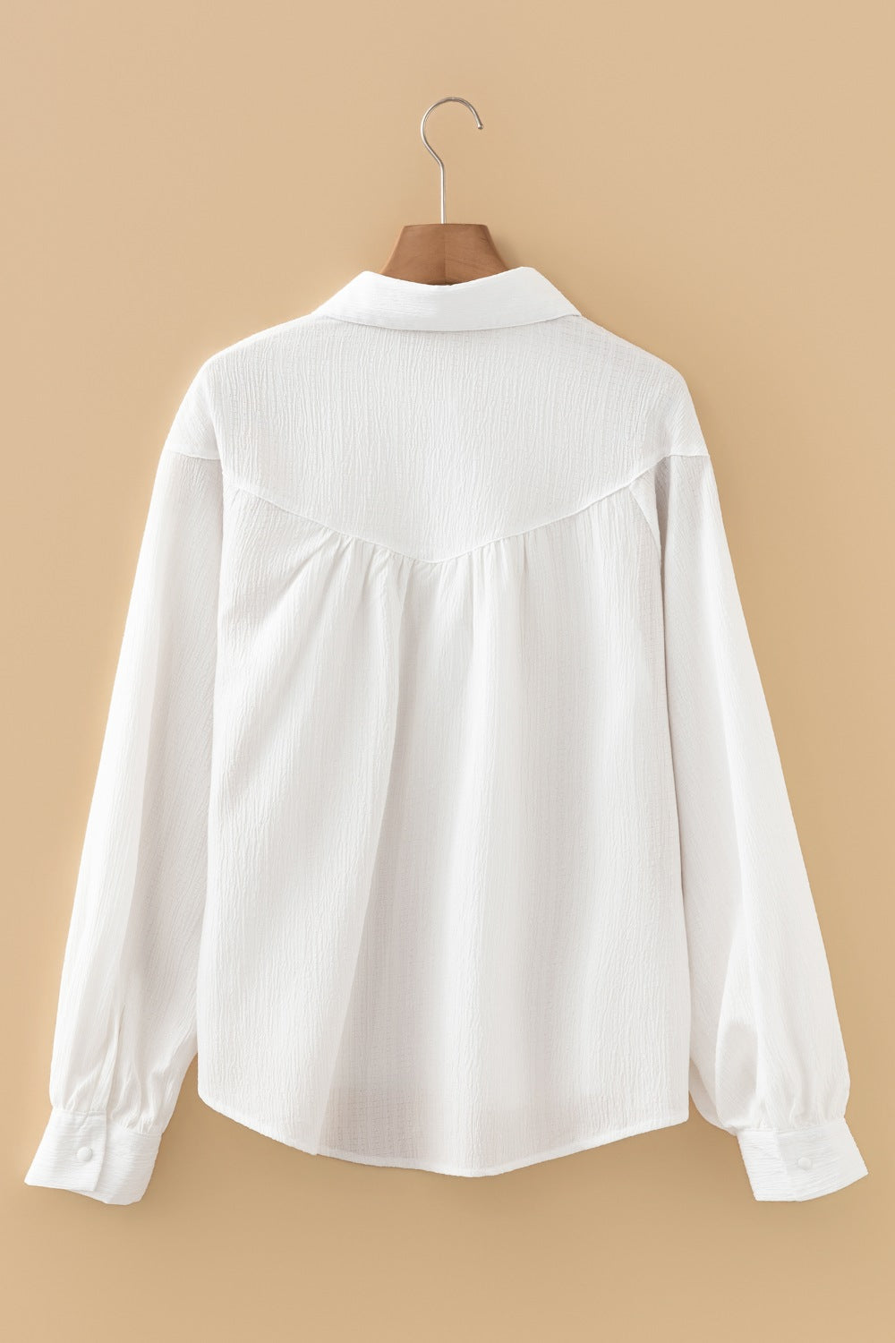 White crinkled texture shirt with classic collar and lantern sleeves.
