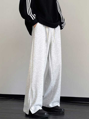 Men's light gray relaxed fit sweatpants with drawstring and zippered leg openings.