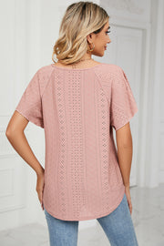 Pink eyelet blouse with flutter sleeves and a scoop neckline.