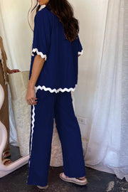 Dark blue scalloped edge co-ord set with white trim on sleeves and pants.