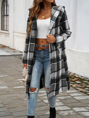 Checked plaid hooded duster coat in black and white, buttoned, long sleeves, open front.