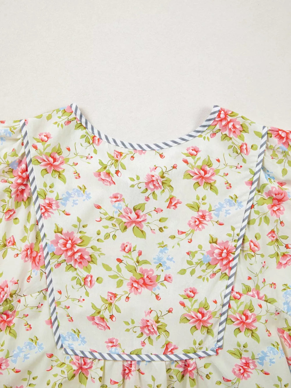 Cotton floral dress with puff sleeves and grey striped trim.