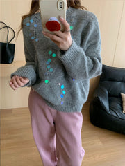 Gray diamond knit sweater with scattered iridescent sequins and a crew neck.