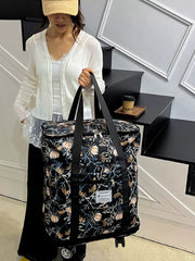 Black floral print rolling travel bag with black straps and wheels