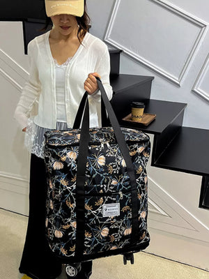 Black floral print rolling travel bag with black straps and wheels