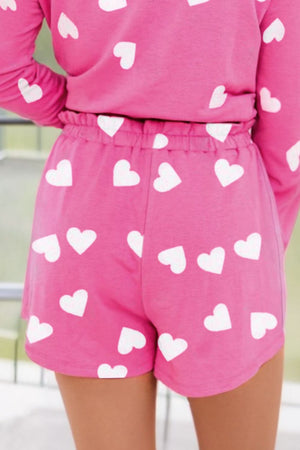 Hot pink pajama shorts with white heart print and elastic waist.