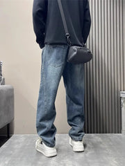 Men's blue washed oversized jeans with tapered cuffs and a relaxed fit.