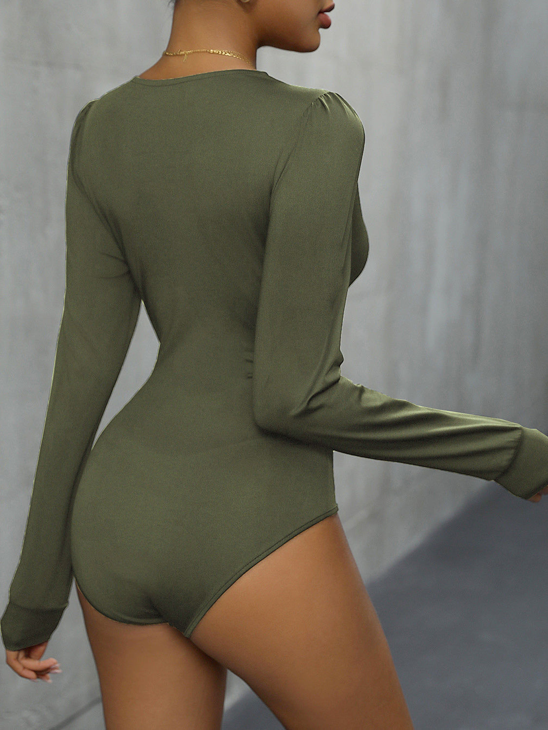 Long sleeve bodysuit in Matcha Green with subtle puff shoulders and a high-cut leg.