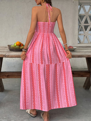 Pink halter neck midi dress with geometric print and tiered skirt.