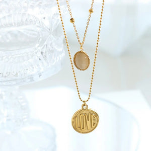 Gold layered necklace with oval stone and LOVE coin pendant