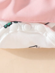 Baby dress with pink top, white bunny print, and snap closure detail.
