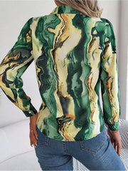 Women's abstract swirl print silk blouse in green and yellow with button cuffs.