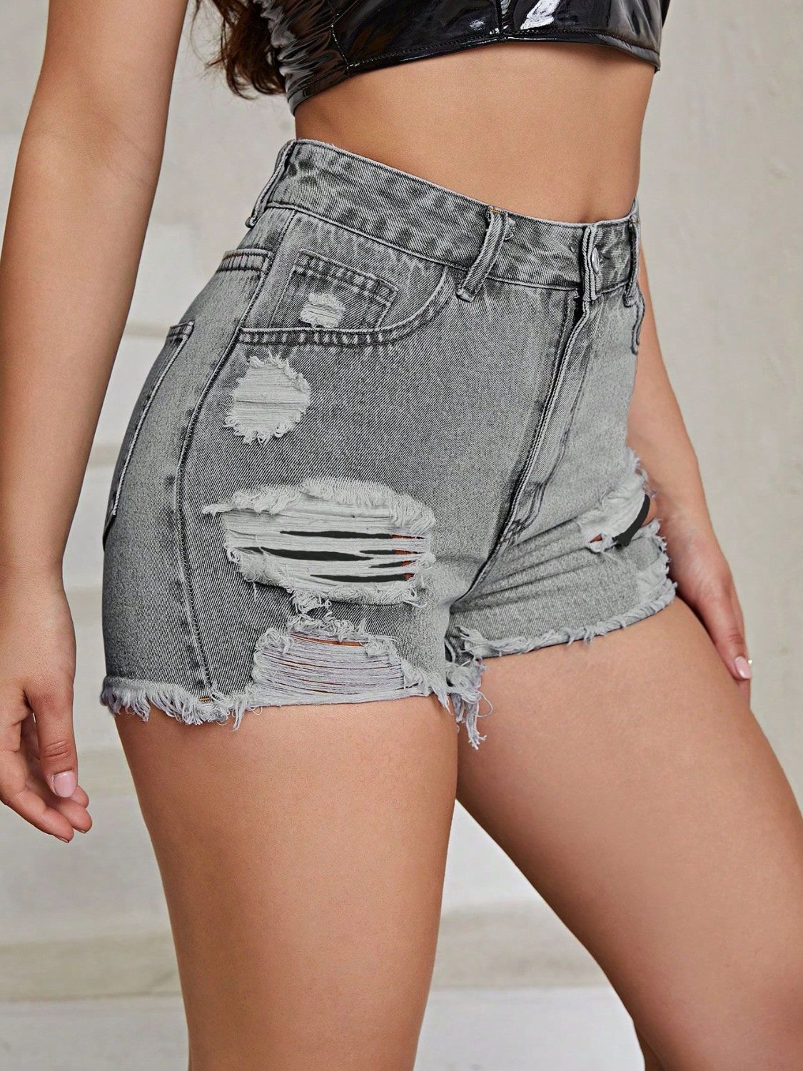 Gray distressed denim shorts with frayed hem and ripped details.
