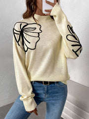 Pastel yellow acrylic knit sweater with black embroidered floral motifs on the shoulder and sleeve.