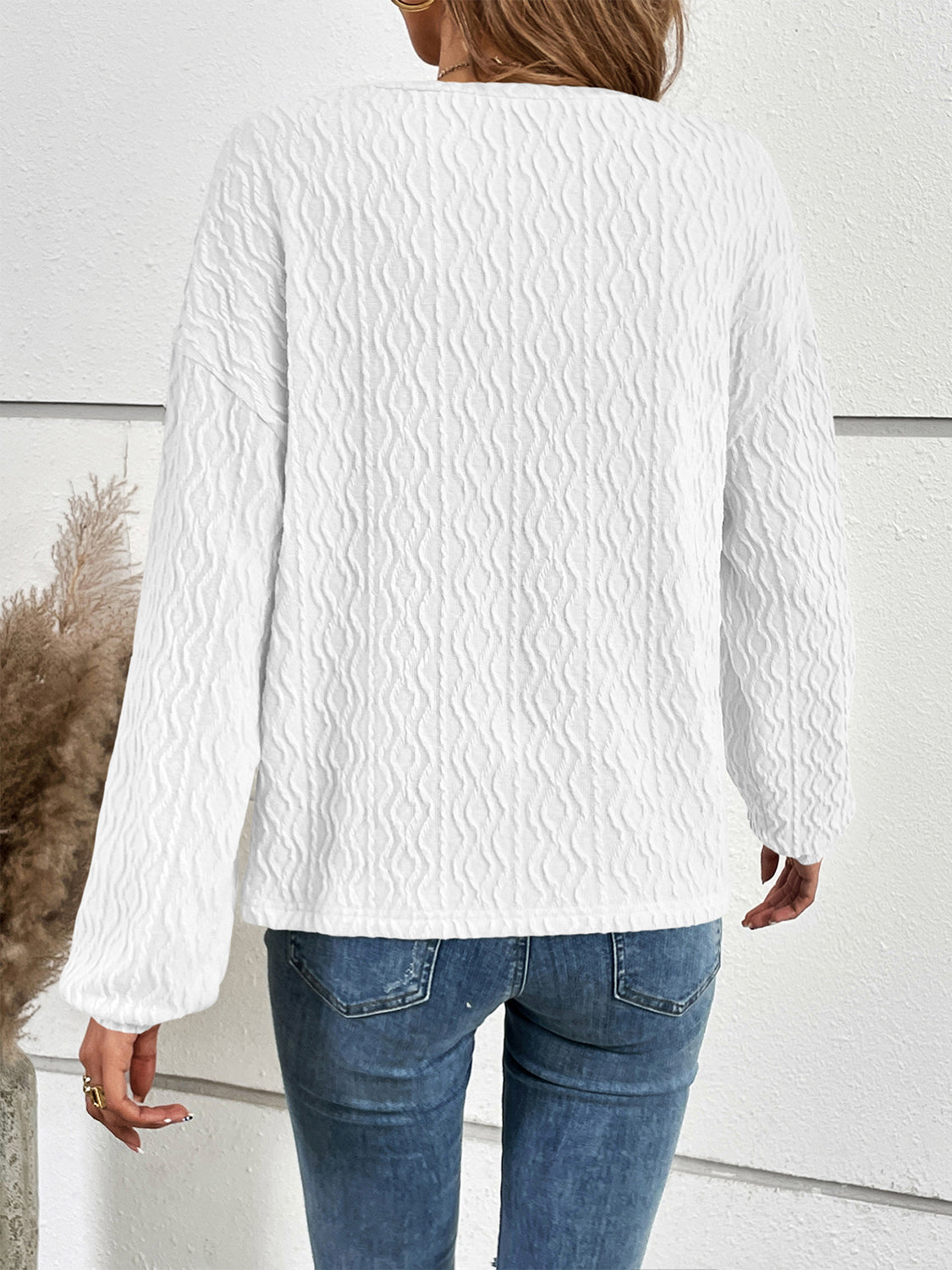 White textured henley blouse with blouson sleeves and button detail.