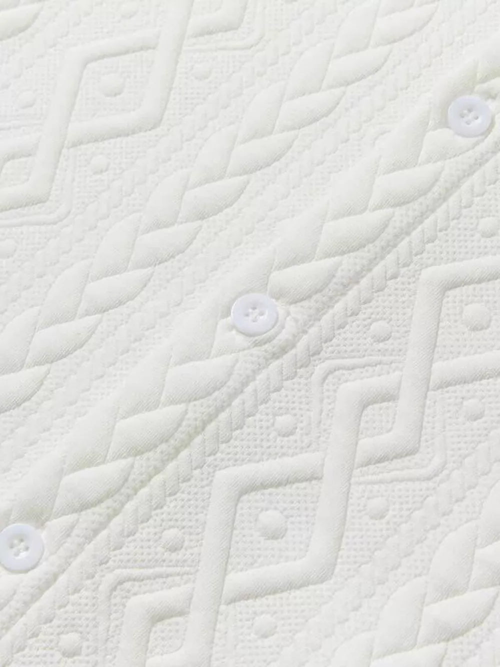 Off-white knit polo with textured geometric pattern and white buttons.