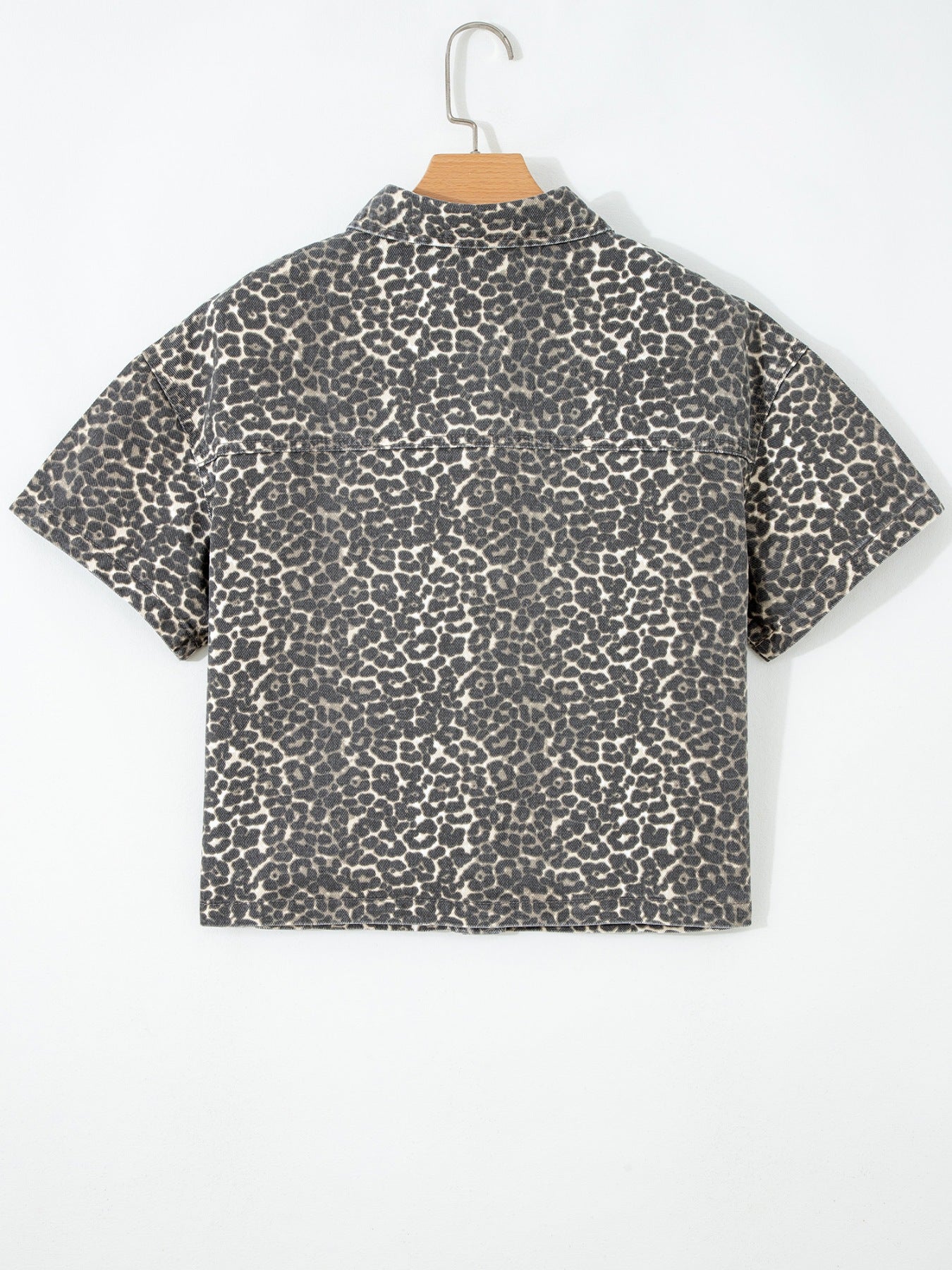 Denim short-sleeve shirt with leopard print, collared neckline, and button-up front.