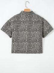 Denim short-sleeve shirt with leopard print, collared neckline, and button-up front.