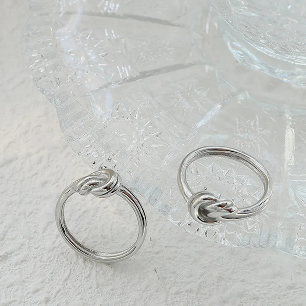Sterling silver ring with knot detail, available in silver and gold.