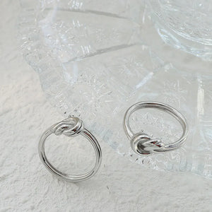 Sterling silver ring with knot detail, available in silver and gold.