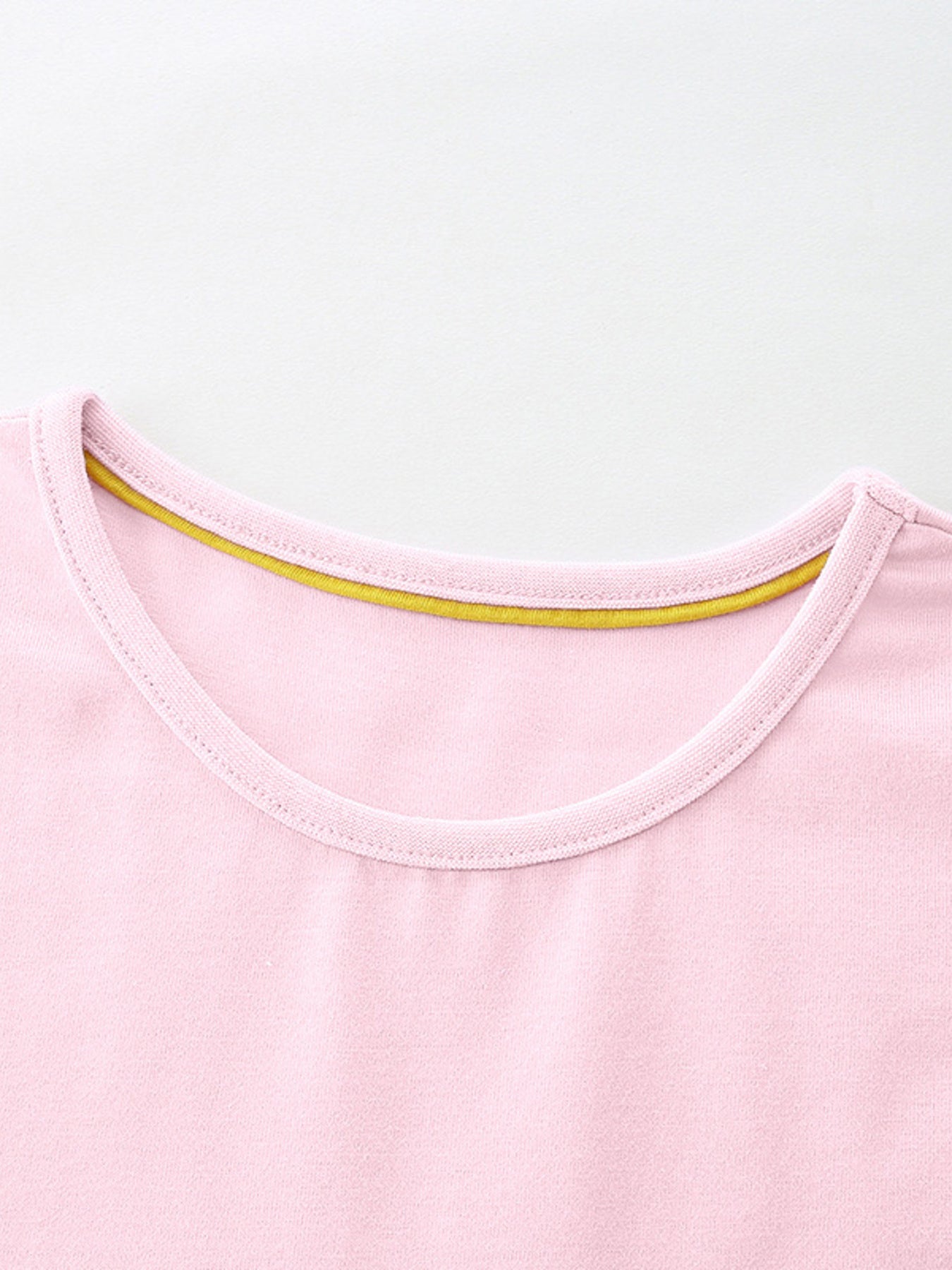 Pink cotton toddler dress with yellow trim at the neckline.