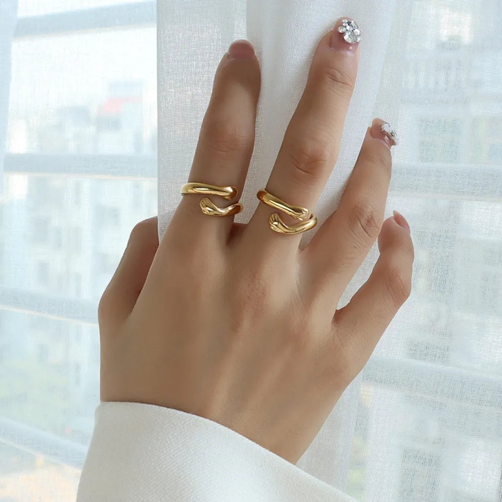 Gold open ring with embracing hands design, chic and casual style.