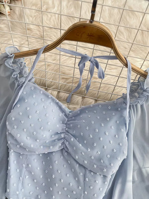 Blue Swiss dot maternity blouse with ruffled neckline and tie halter.