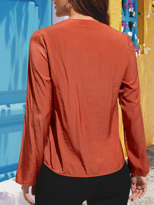 Red orange silk-effect blouse with button detail and long sleeves.