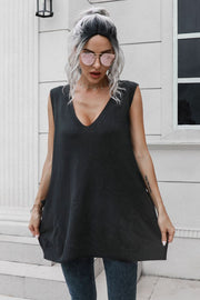 Black oversized knit vest with V-neck and pockets, styled with jeans.