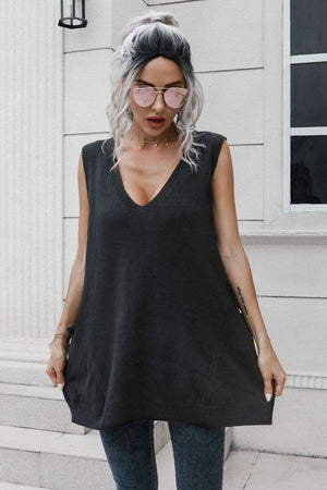 Black oversized knit vest with V-neck and pockets, styled with jeans.