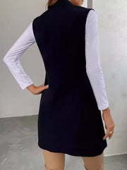 Black draped lapel vest with asymmetric hemline worn over a white long-sleeve top.