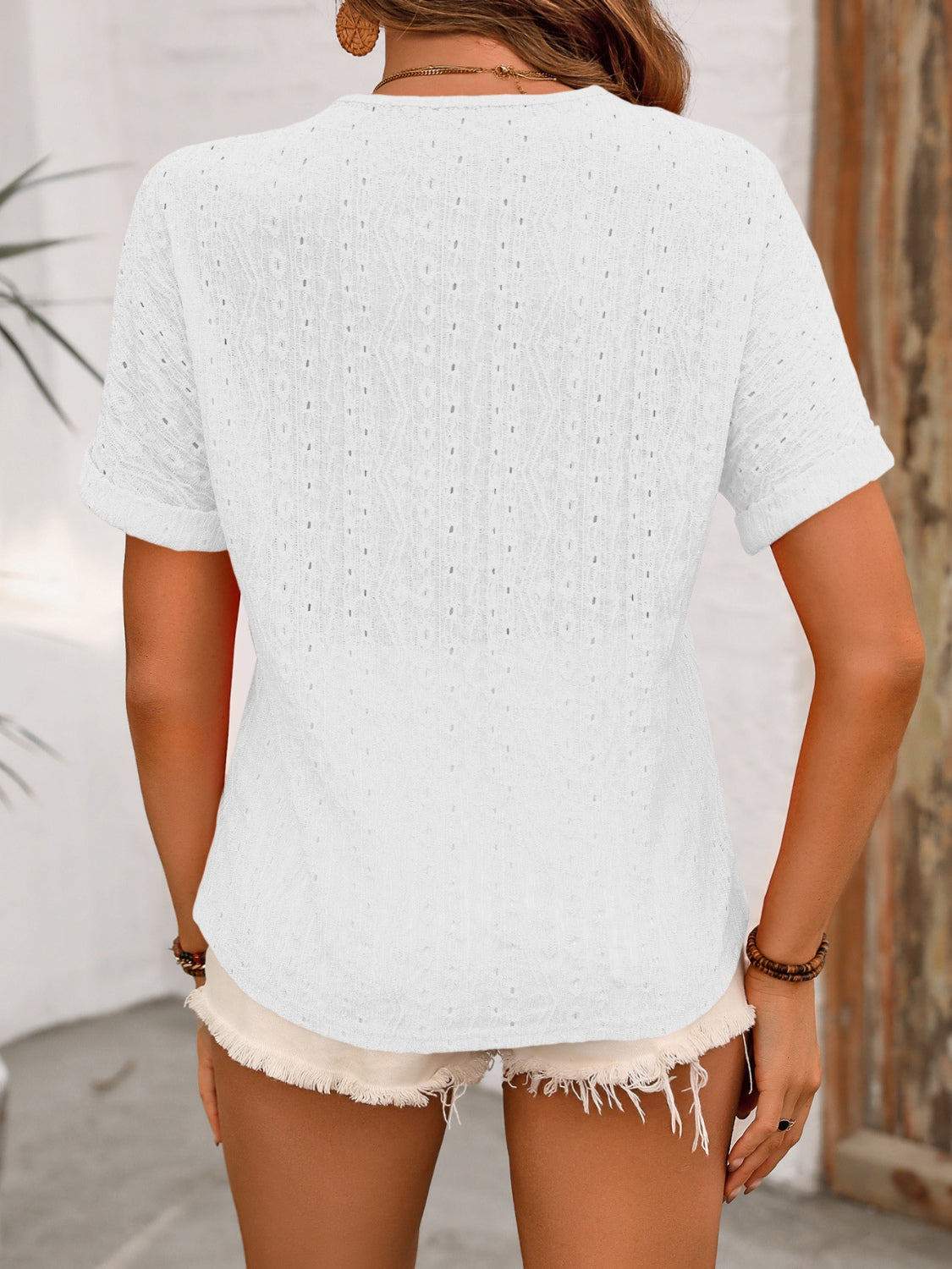White eyelet henley relaxed fit top with short sleeves and a textured pattern.