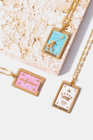 Tarot card pendant necklaces in light blue, blush pink, and white with gold chains.