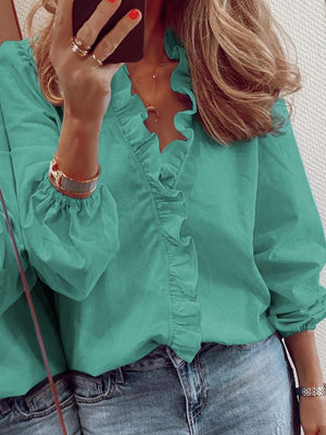 Teal blouse with cascading ruffle front and balloon sleeves.