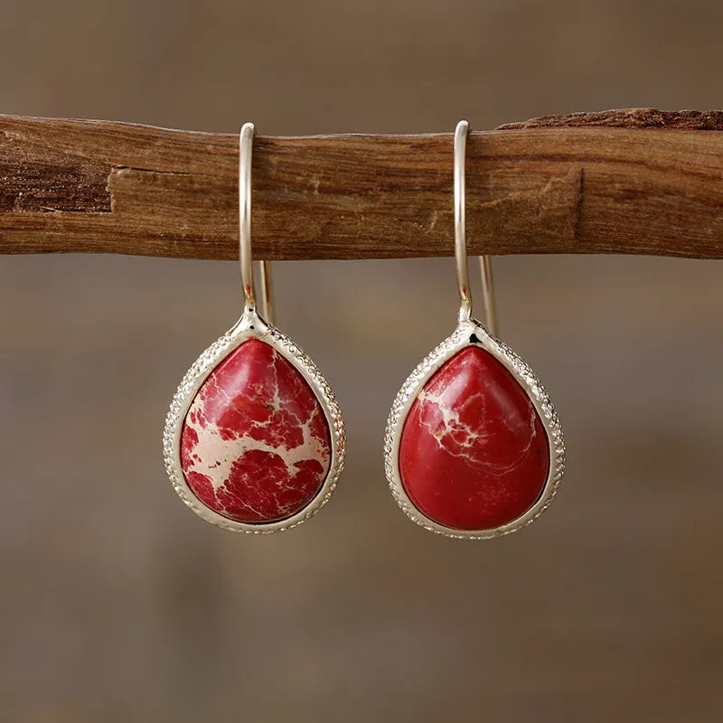 Marbled teardrop earrings in deep red with bezel setting and 18K gold-plated hooks.