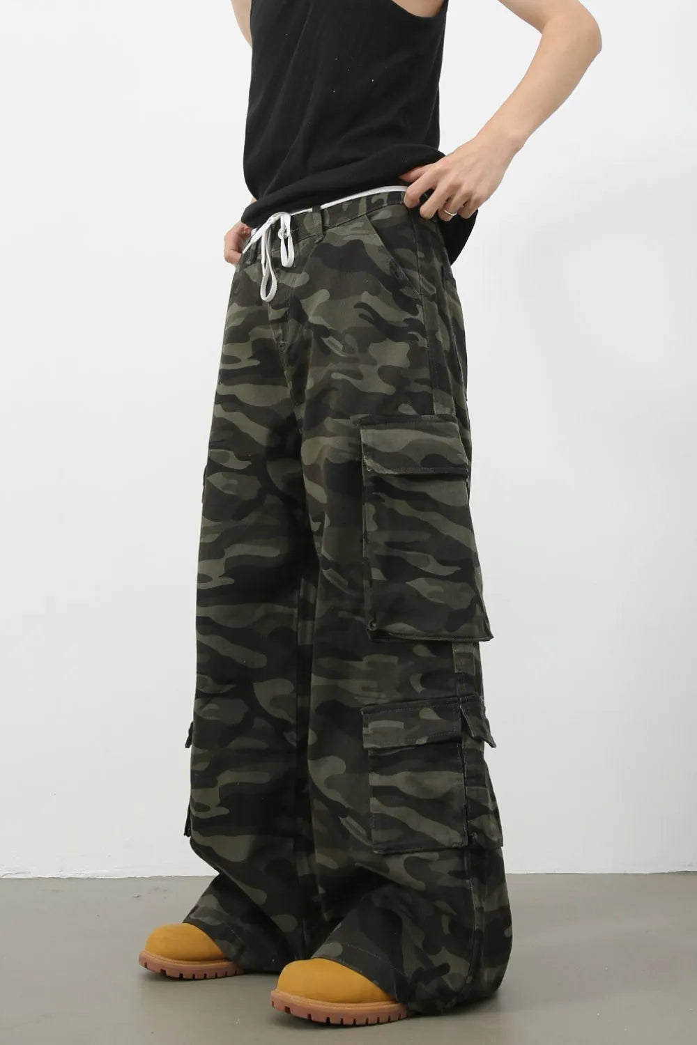 Wide-leg camo cargo pants with drawstring waist and multiple pockets.