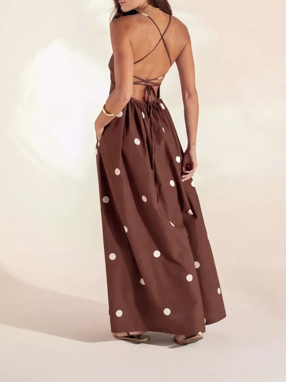 Brown polka dot maxi dress with pockets and backless crisscross straps.