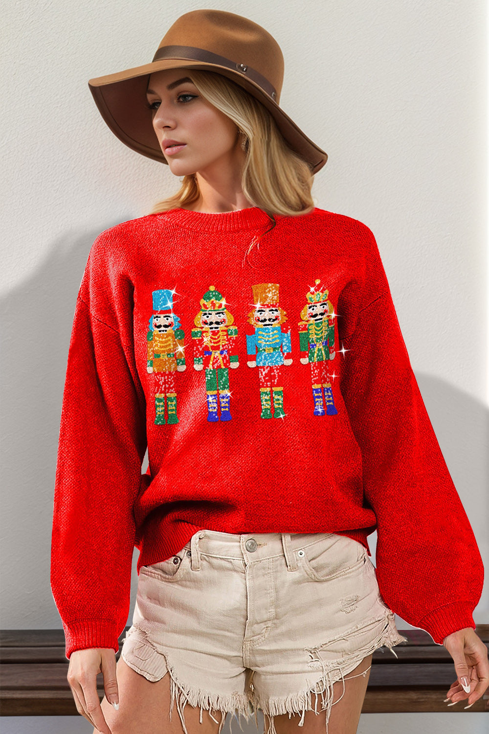 Red knit sweater with sequin nutcracker embellishment and balloon sleeves.