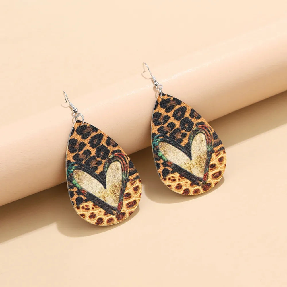 Leopard print teardrop earrings with a heart detail and rainbow accents.
