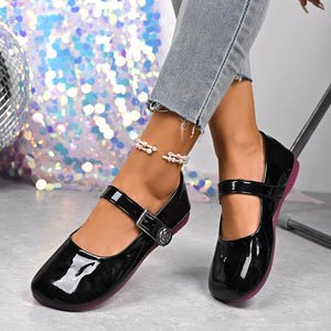 Black patent buckle strap Mary Jane loafers with a rose detail and purple sole.