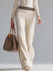 Milky white ribbed hooded jumpsuit with striped trim and quarter-zip detail.