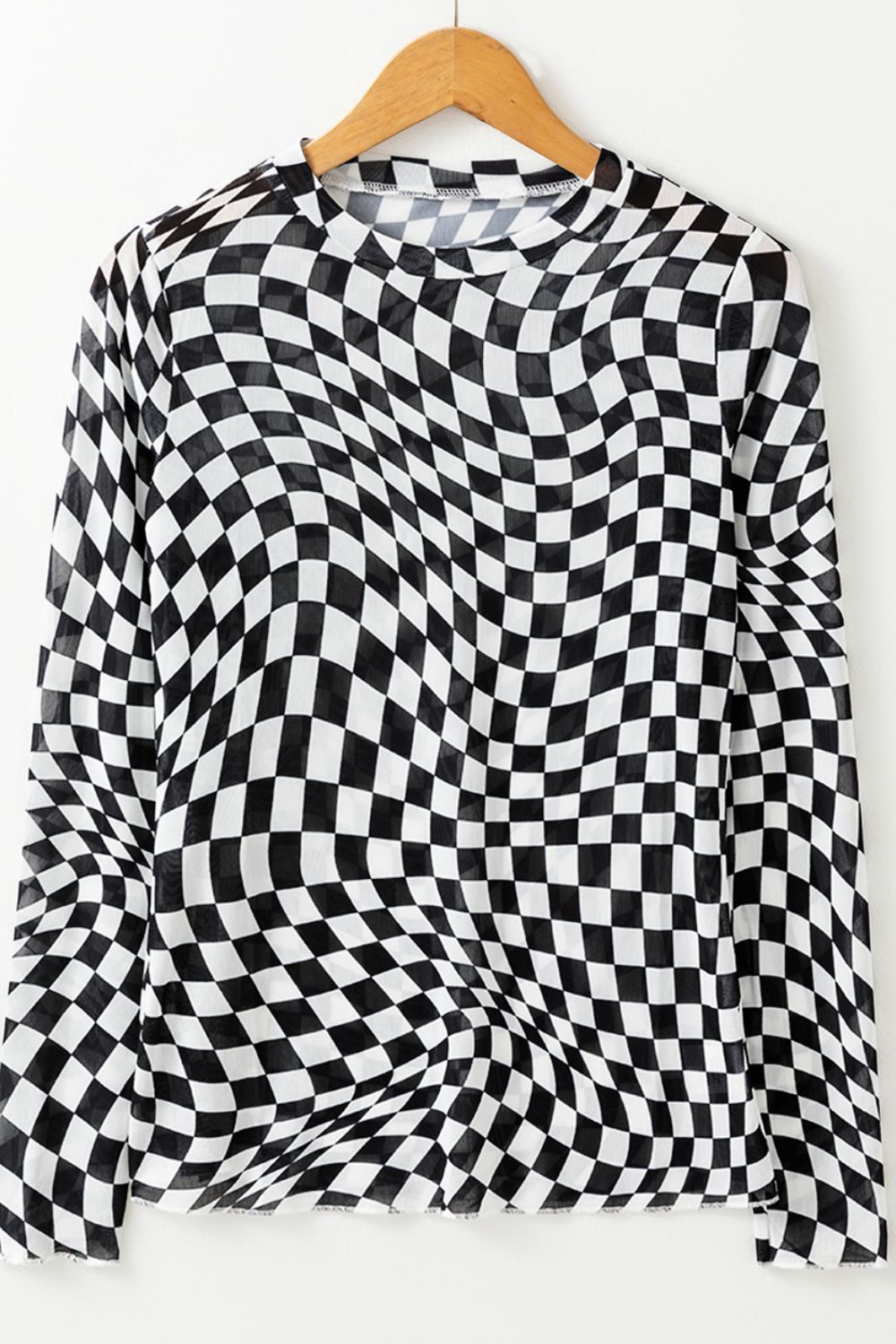 Black and white optical illusion checkered mesh long sleeve blouse with crew neck.