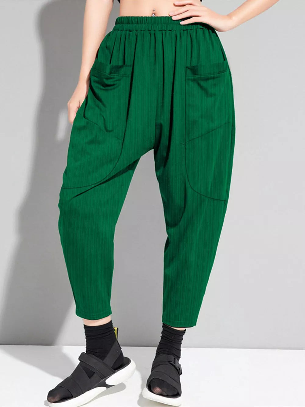 Dark green plus size harem pants with pockets and a ribbed texture.